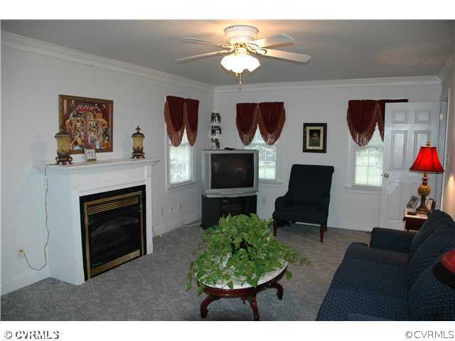 17363 Parsons Ridge Road Beaverdam, VA 23015 - Photo 4 of 12 a living room with furniture a flat screen tv and a fireplace