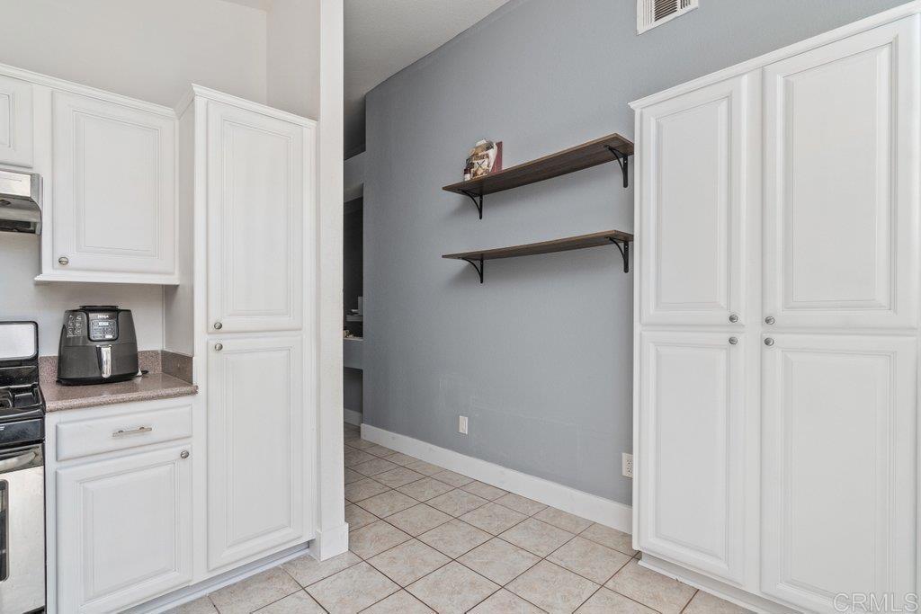 32467 Cervin Circle Temecula, CA 92592 - Photo 12 of 36 a view of a kitchen with white cabinets and a refrigerator