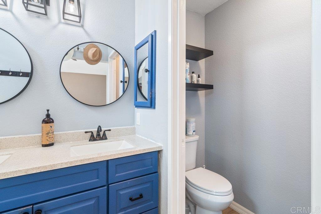 32467 Cervin Circle Temecula, CA 92592 - Photo 21 of 36 a bathroom with a toilet a sink and mirror