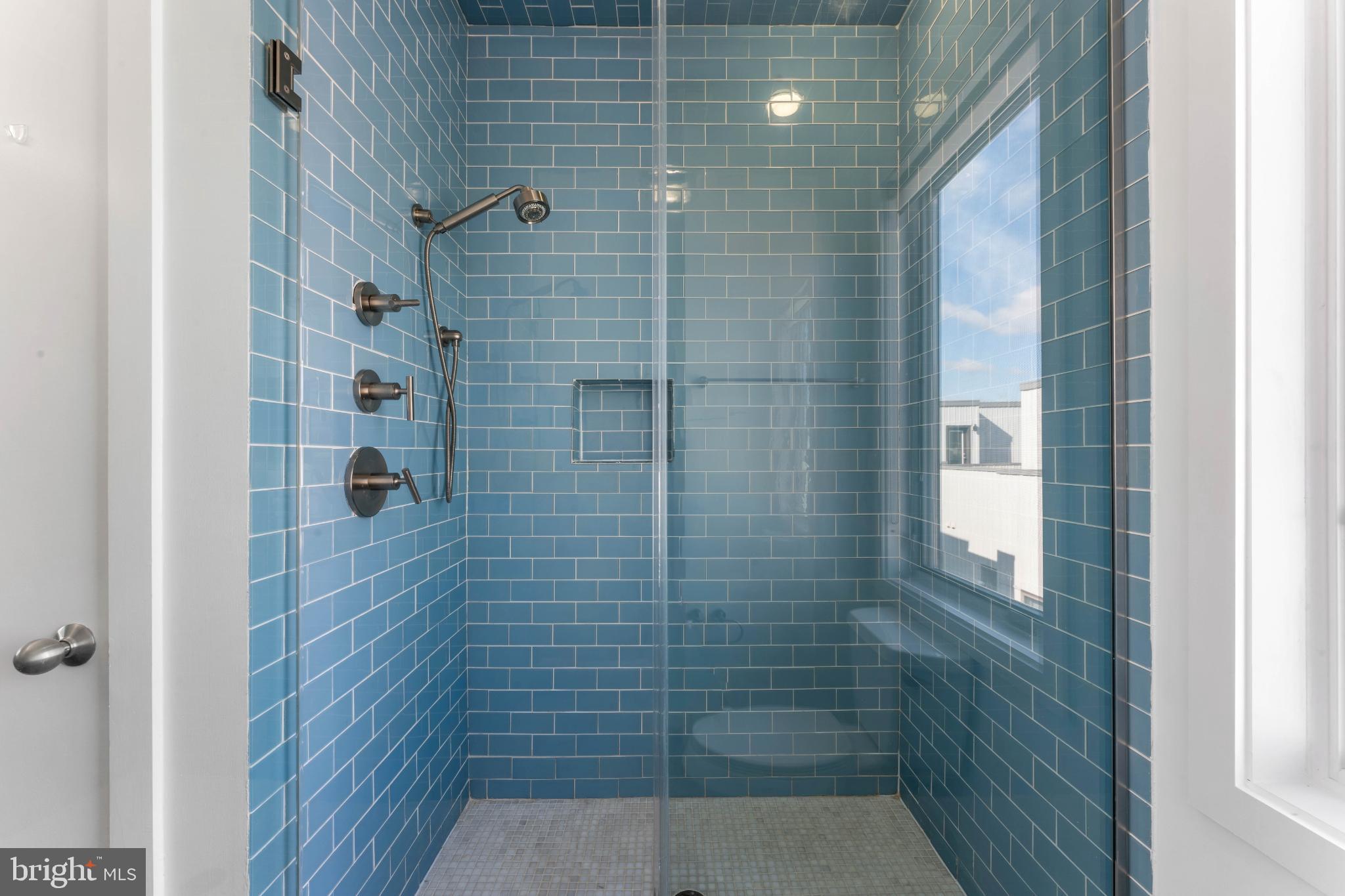 333 Green Street, Unit 7 Philadelphia, PA 19123 - Photo 31 of 40 Sleek blue-tiled shower with natural light.