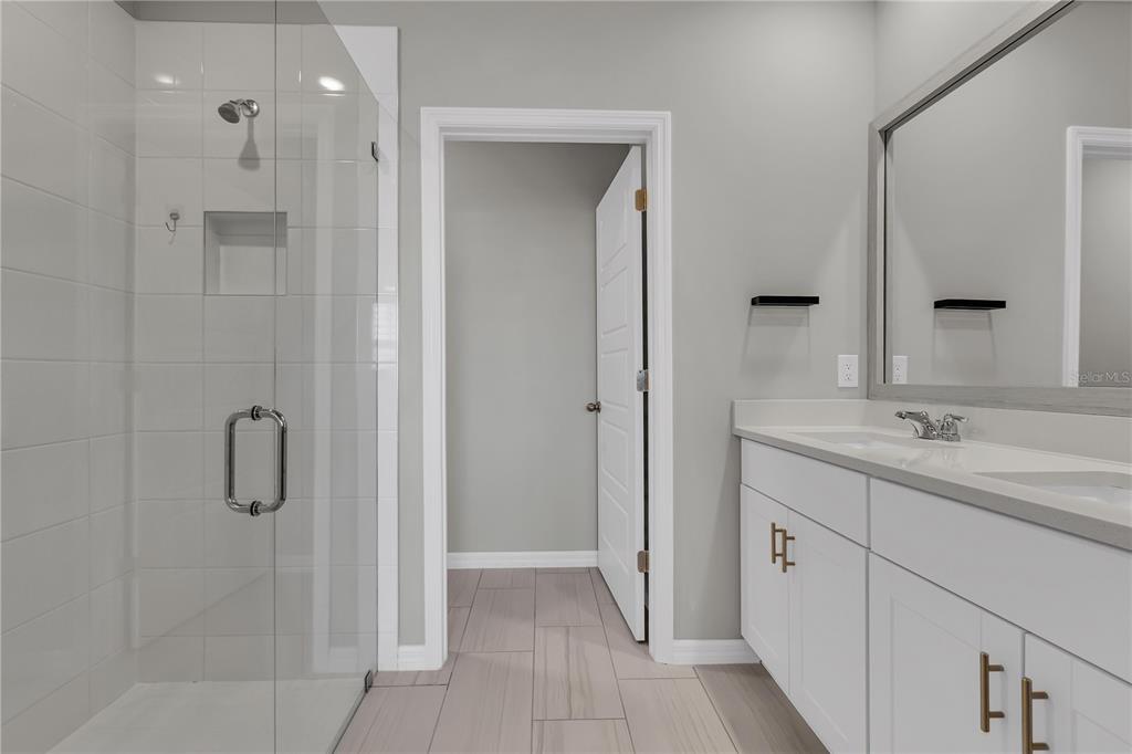 44254 Frontier Drive Punta Gorda, FL 33982 - Photo 21 of 48 a bathroom with a shower sink and mirror