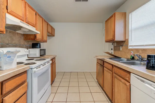 a kitchen with a sink stove and cabinets