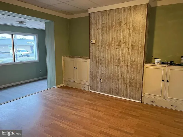 an empty room with wooden floor and cabinet