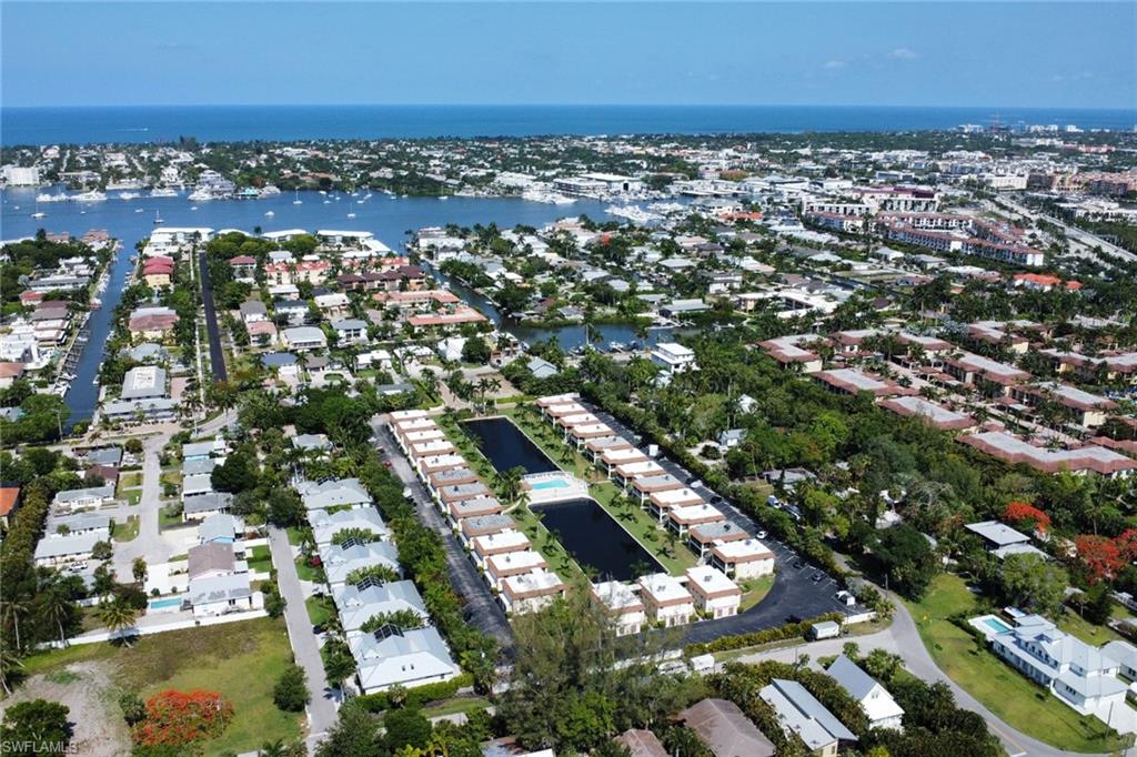 Aerial view of property and surrounding area with a large body of water and nearby suburban area