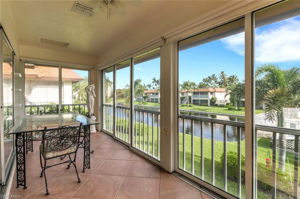 1155 Sandpiper Street, Unit D4 Naples, FL 34102 - Photo 11 of 39 Sunroom featuring a water view, tile patterned flooring, a ceiling fan, and a residential view