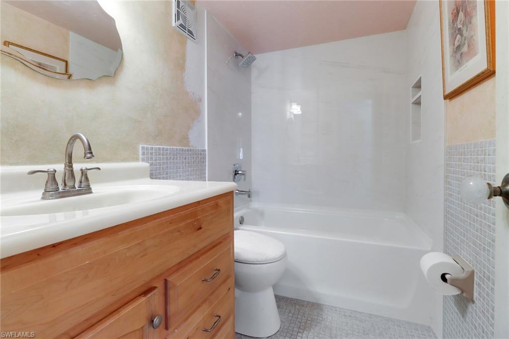 1155 Sandpiper Street, Unit D4 Naples, FL 34102 - Photo 17 of 39 Full bath featuring vanity, shower / washtub combination, and tile patterned flooring