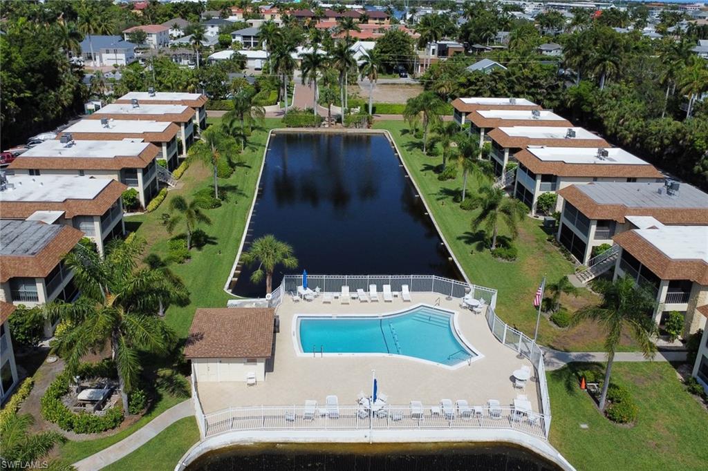 1155 Sandpiper Street, Unit D4 Naples, FL 34102 - Photo 18 of 39 Aerial view of a nearby body of water and a pool area