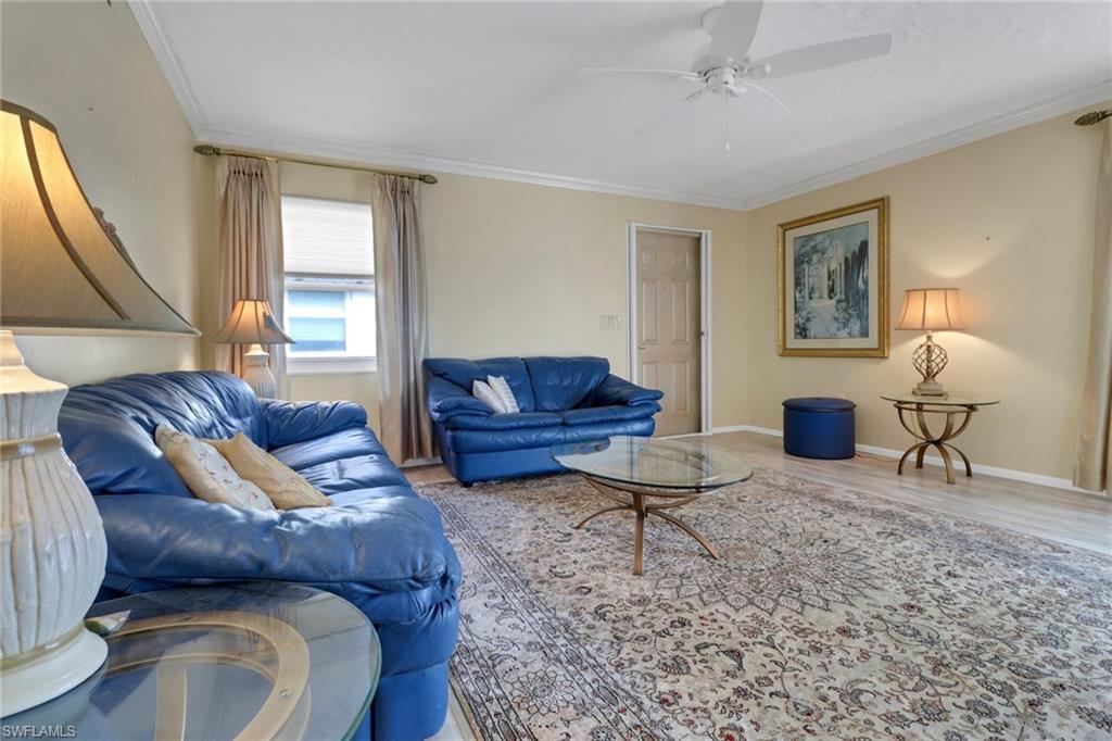 1155 Sandpiper Street, Unit D4 Naples, FL 34102 - Photo 28 of 39 Living room featuring ornamental molding, wood finished floors, and a ceiling fan