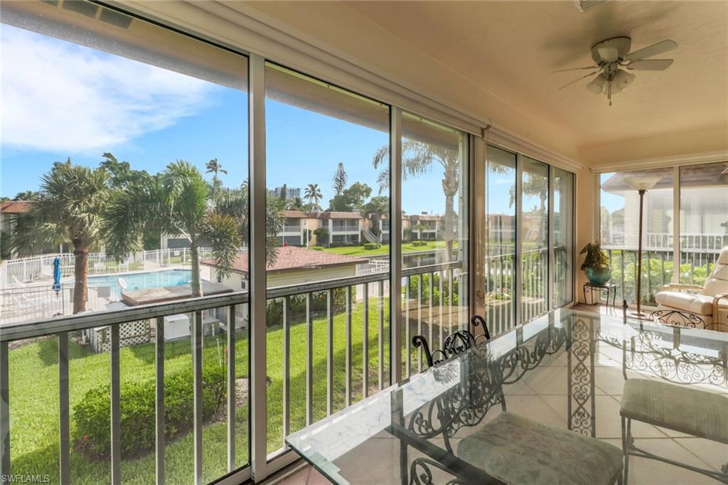 1155 Sandpiper Street, Unit D4 Naples, FL 34102 - Photo 3 of 39 Sunroom / solarium featuring tile patterned floors, a residential view, and a water view