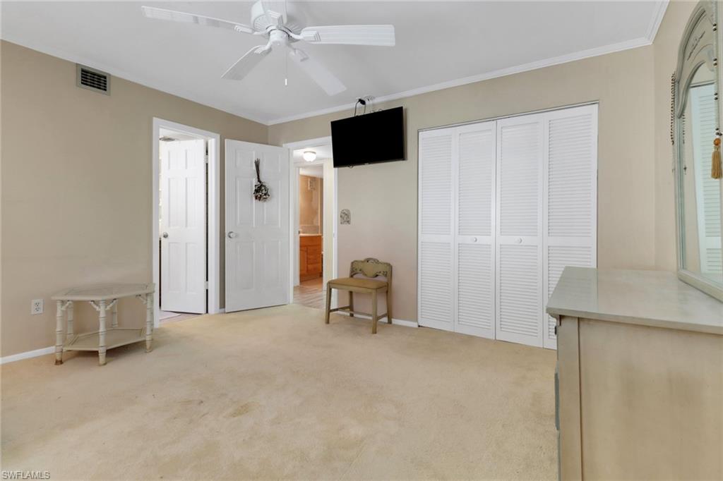 1155 Sandpiper Street, Unit D4 Naples, FL 34102 - Photo 32 of 39 Unfurnished bedroom featuring light carpet, ornamental molding, a closet, and ceiling fan