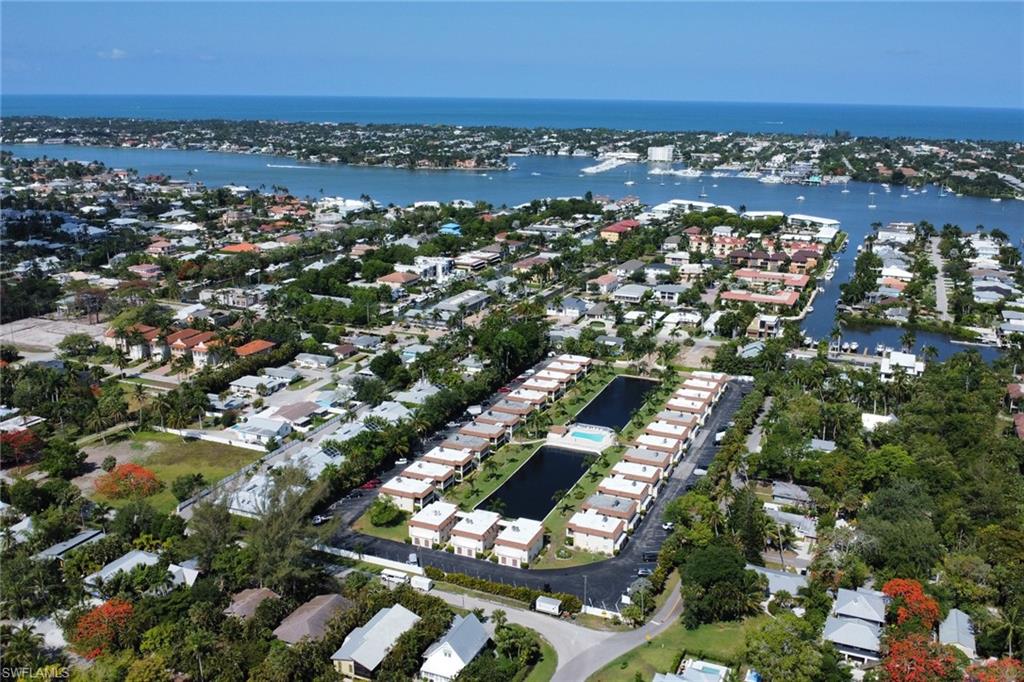 1155 Sandpiper Street, Unit D4 Naples, FL 34102 - Photo 36 of 39 Aerial view of property and surrounding area featuring a large body of water and nearby suburban area