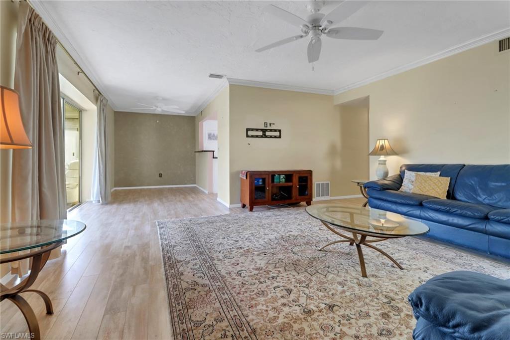1155 Sandpiper Street, Unit D4 Naples, FL 34102 - Photo 4 of 39 Living room with ceiling fan, crown molding, and light wood-style flooring