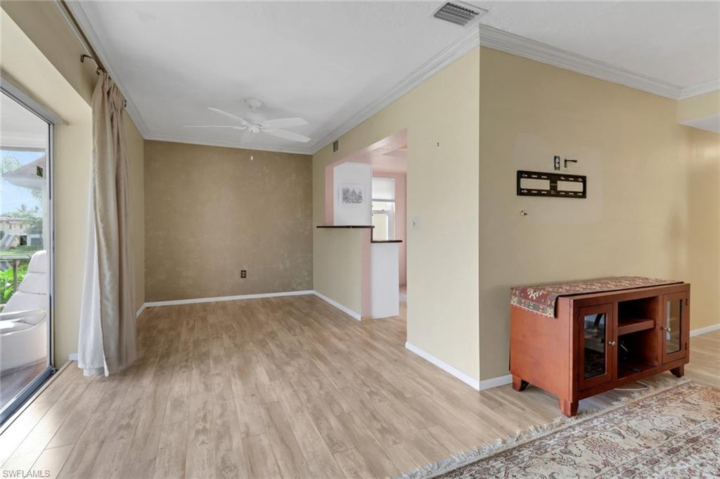 1155 Sandpiper Street, Unit D4 Naples, FL 34102 - Photo 9 of 39 Empty room with crown molding, light wood-type flooring, healthy amount of natural light, and a ceiling fan