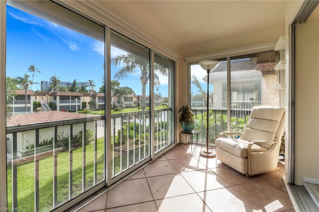 1155 Sandpiper Street, Unit D4 Naples, FL 34102 - Photo 10 of 39 Sunroom featuring a water view, tile patterned flooring, and a residential view