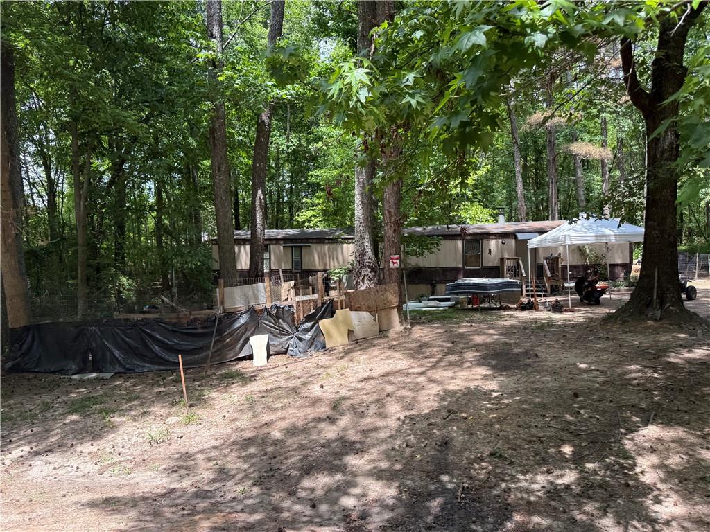 190 Akin Road Carrollton, GA 30117 - Photo 3 of 4 a view of a patio with table and chairs and large trees