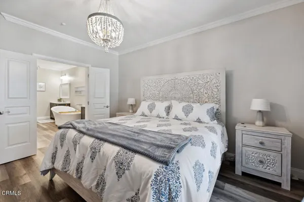 a bedroom with a bed and a chandelier
