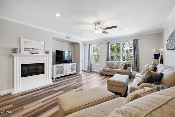 a living room with furniture a flat screen tv and a fireplace