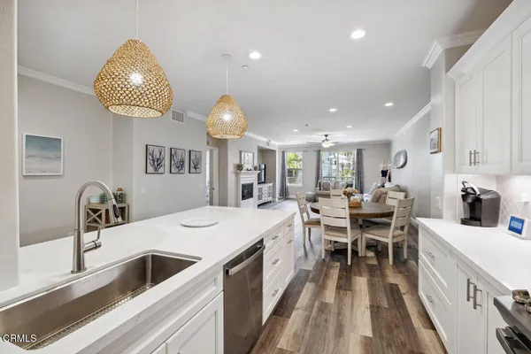 a kitchen with stainless steel appliances granite countertop a sink dining table and chairs
