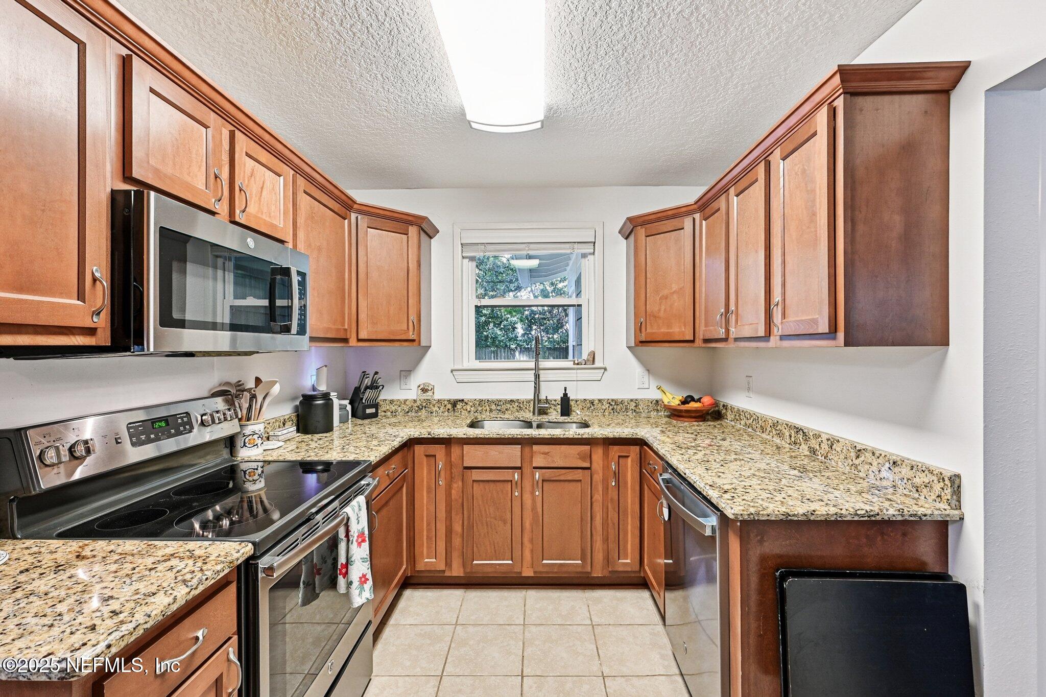 4637 Homestead Road Jacksonville, FL 32210 - Photo 12 of 43 a kitchen with a sink stove top oven and microwave