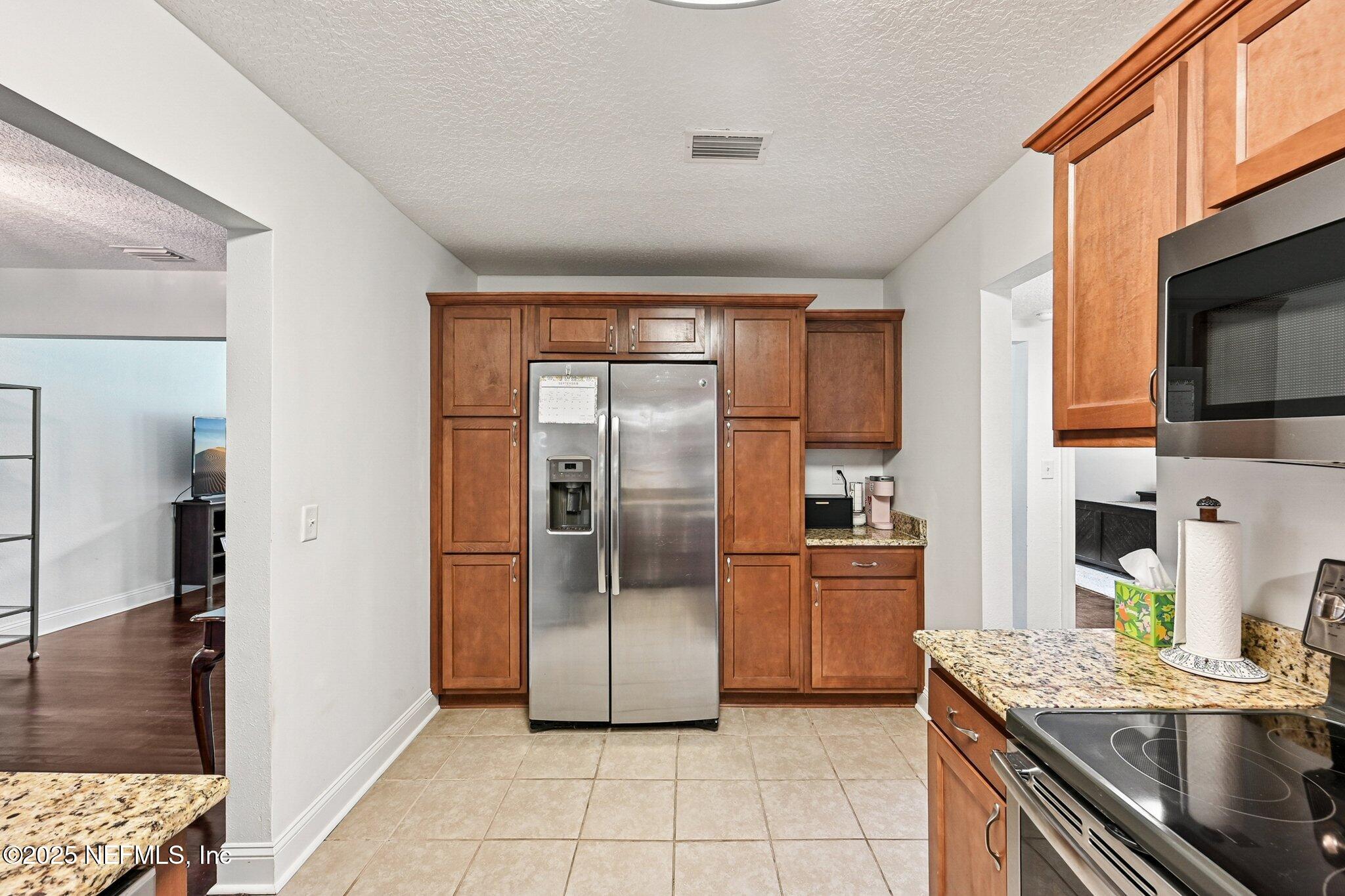 4637 Homestead Road Jacksonville, FL 32210 - Photo 14 of 43 a kitchen with stainless steel appliances granite countertop a refrigerator and a stove