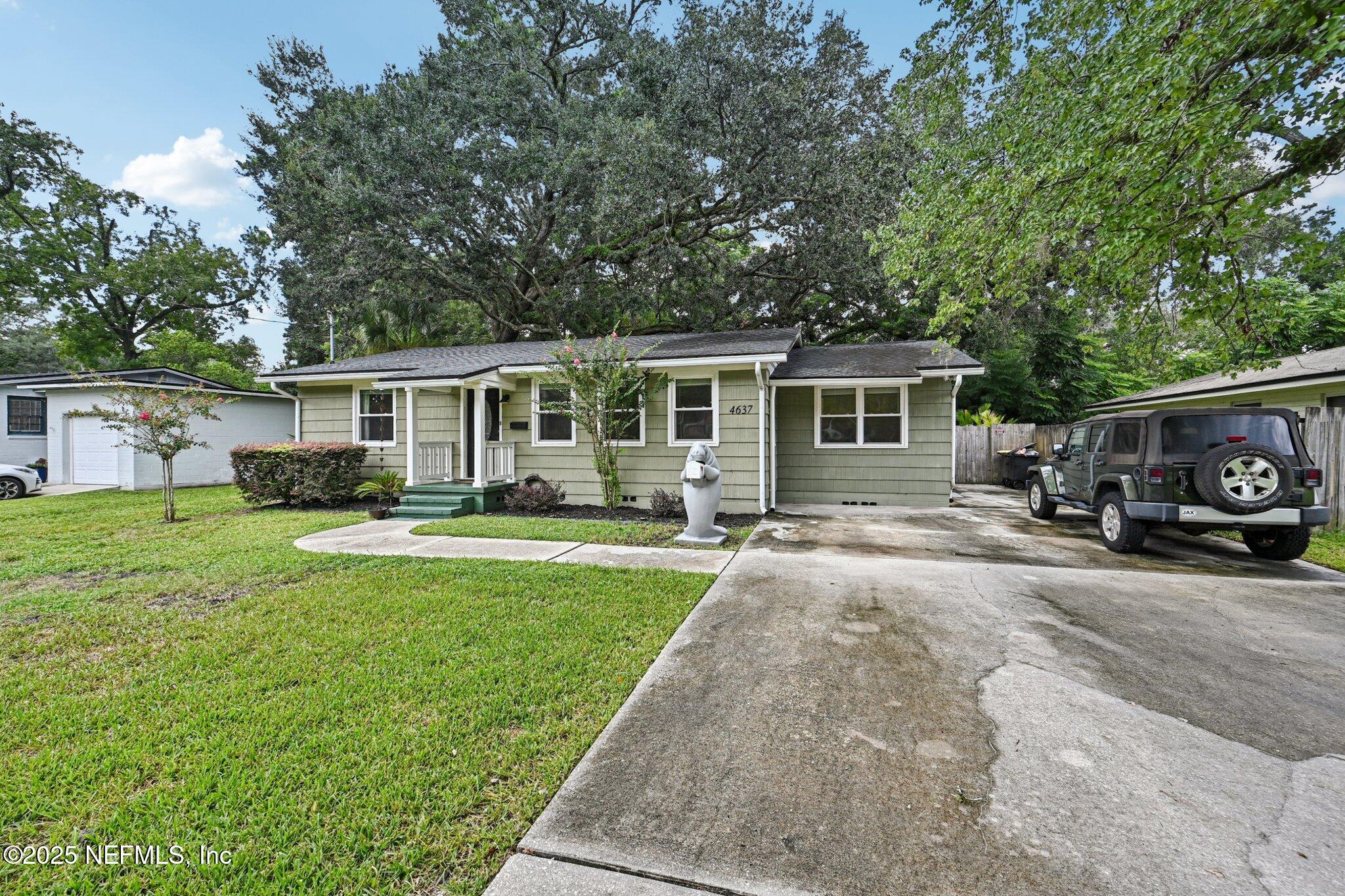 4637 Homestead Road Jacksonville, FL 32210 - Photo 2 of 43 a front view of a house with a garden and trees