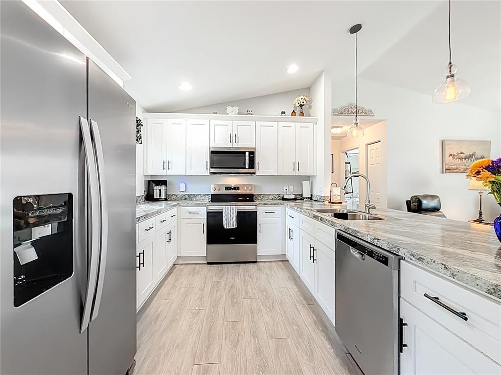 4445 East Maryland Street Inverness, FL 34453 - Photo 21 of 46 a kitchen with stainless steel appliances a refrigerator sink and white cabinets
