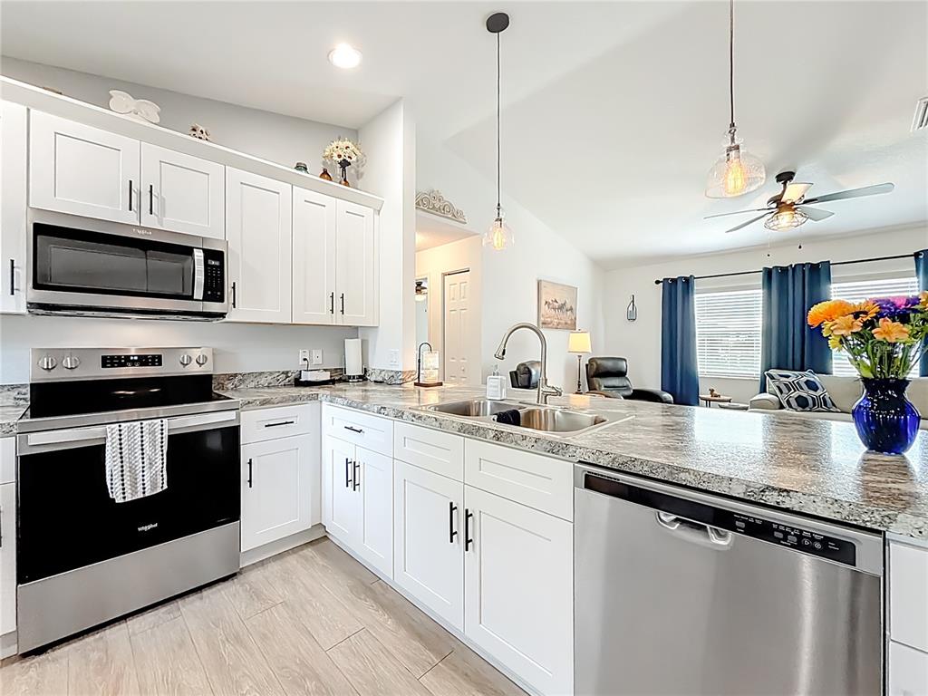 4445 East Maryland Street Inverness, FL 34453 - Photo 23 of 46 a kitchen with stainless steel appliances granite countertop a sink a stove top oven a counter space and cabinets