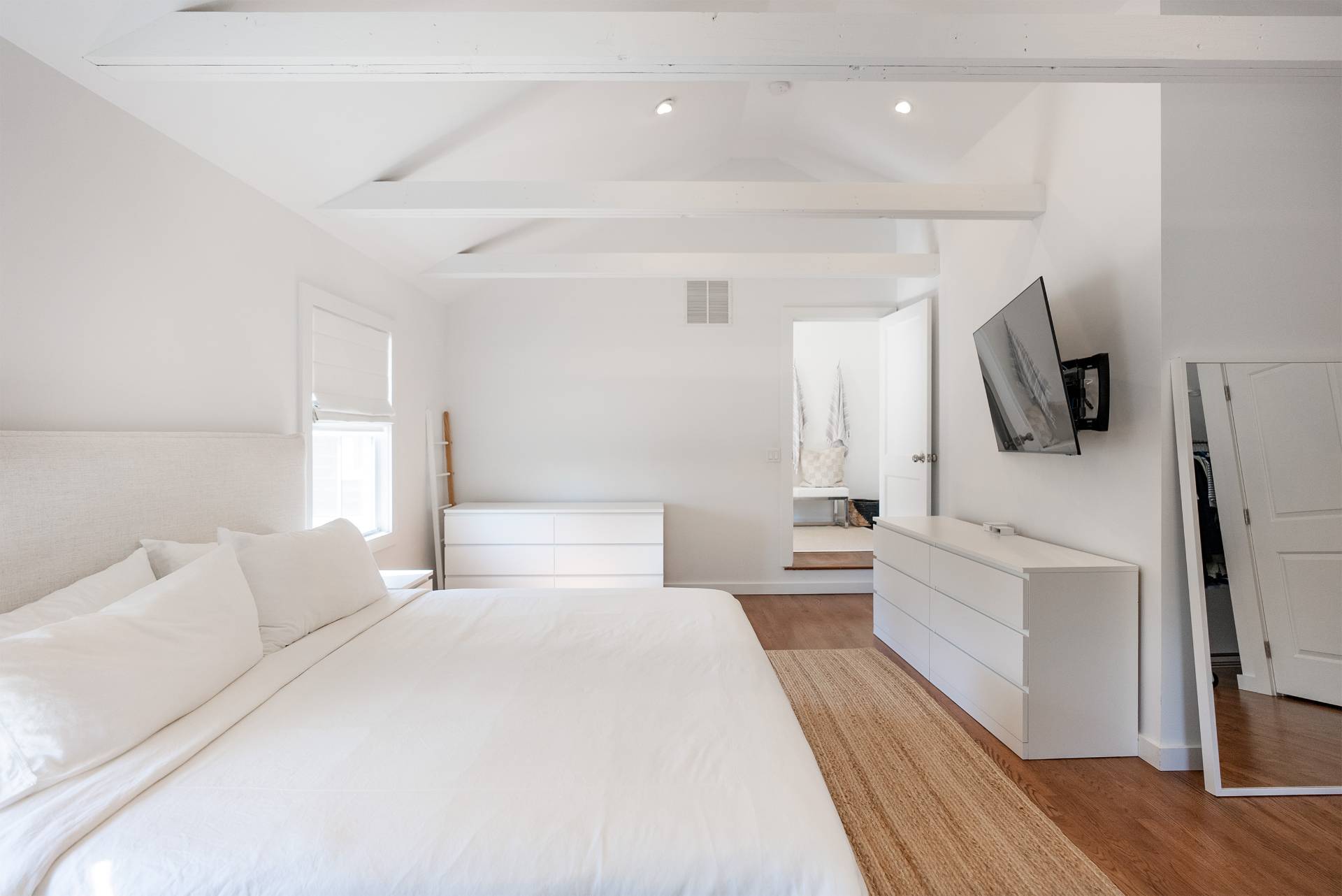 Undisclosed Address Bridgehampton, NY 11932 - Photo 13 of 25 a bedroom with a large bed and a flat tv screen