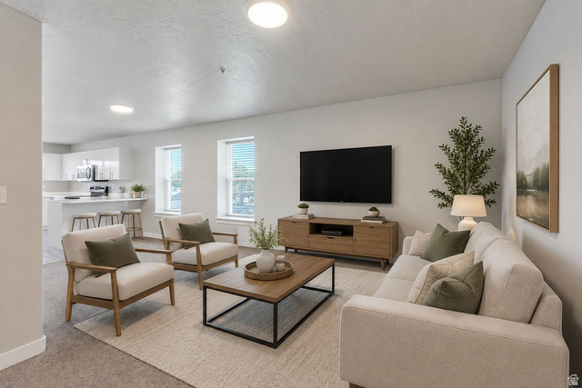572 South 100 West, Unit E210 Springville, UT 84663 - Photo 8 of 35 Open-concept living space featuring recessed lighting, multiple windows, and a kitchen with a breakfast bar and stainless steel appliances