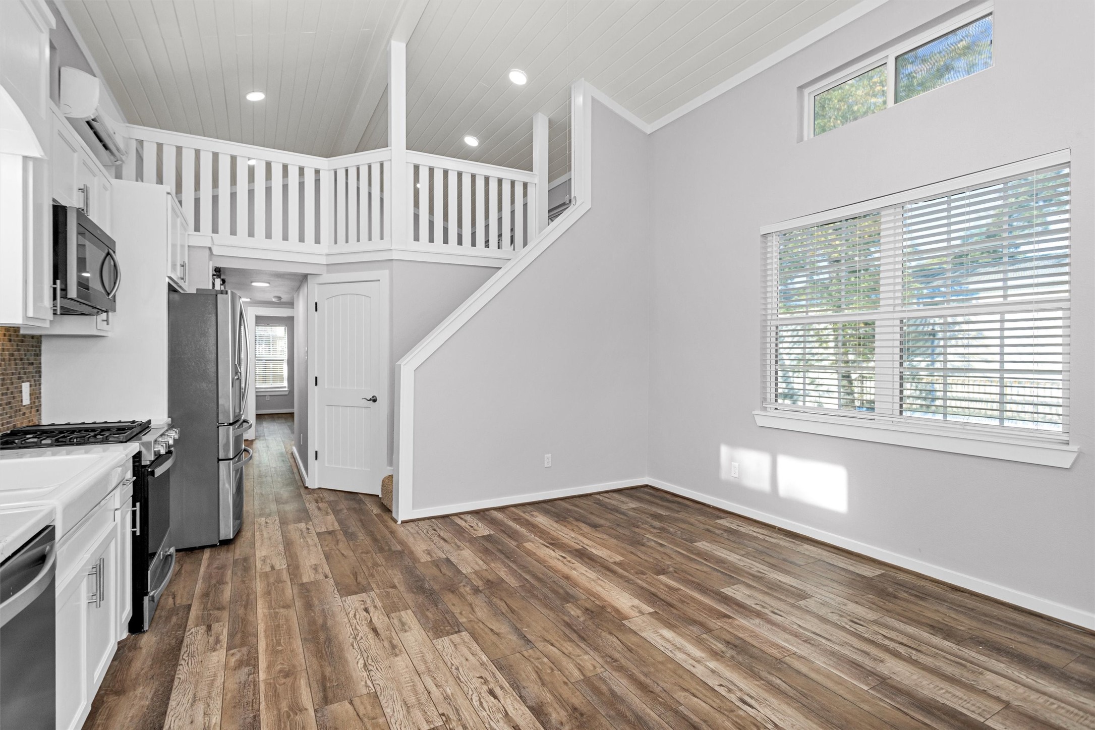 12922 Longstreet Road, Unit 711 Willis, TX 77318 - Photo 5 of 29 a view of entryway with kitchen and wooden floor