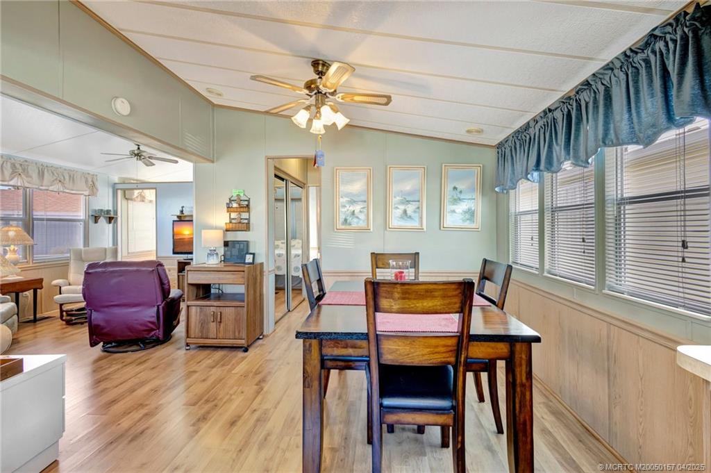 10725 South Ocean Drive, Unit 437 Jensen Beach, FL 34957 - Photo 12 of 32 a dining room with furniture a chandelier and wooden floor