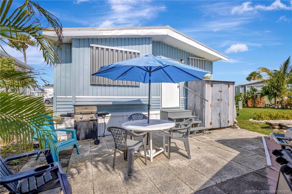 10725 South Ocean Drive, Unit 437 Jensen Beach, FL 34957 - Photo 21 of 32 a patio with a table and chairs under an umbrella