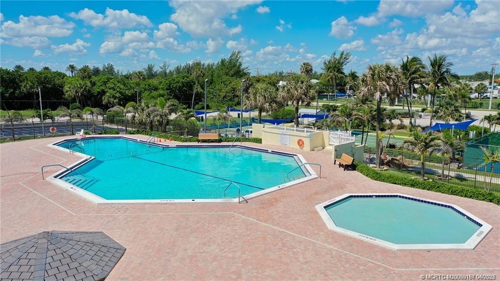 10725 South Ocean Drive, Unit 437 Jensen Beach, FL 34957 - Photo 29 of 32 a view of a swimming pool with a yard and trees