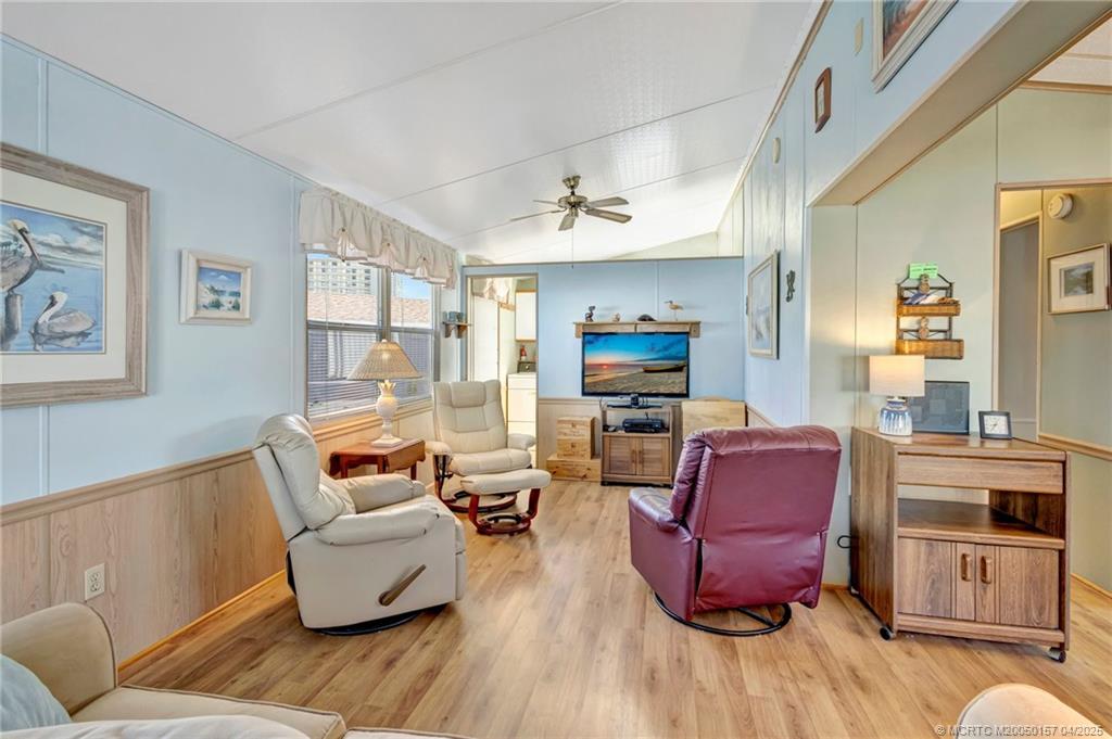 10725 South Ocean Drive, Unit 437 Jensen Beach, FL 34957 - Photo 6 of 32 a living room with furniture a flat screen tv and kitchen view