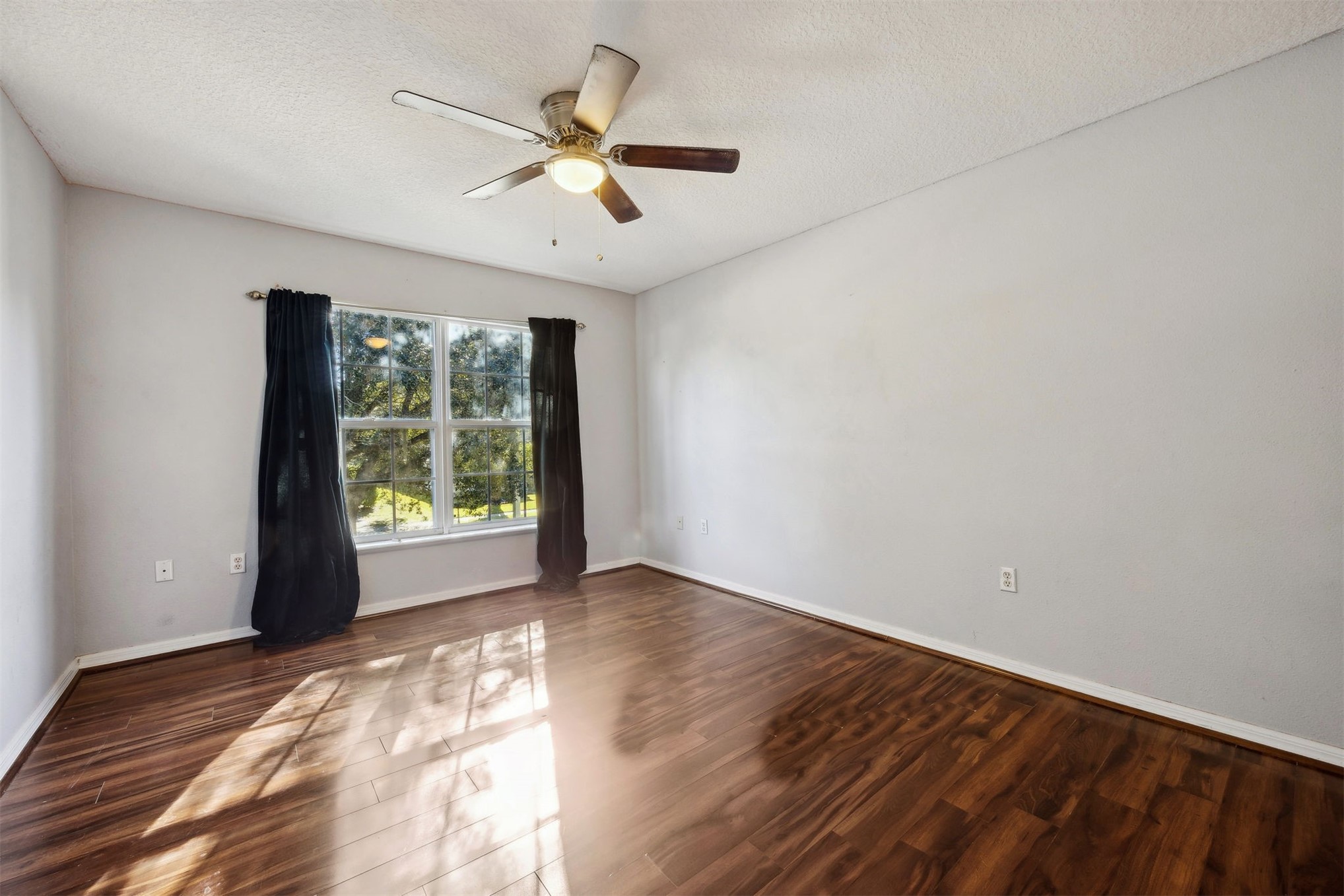 87233 Kipling Drive Yulee, FL 32097 - Photo 32 of 38 an empty room with wooden floor fan and windows