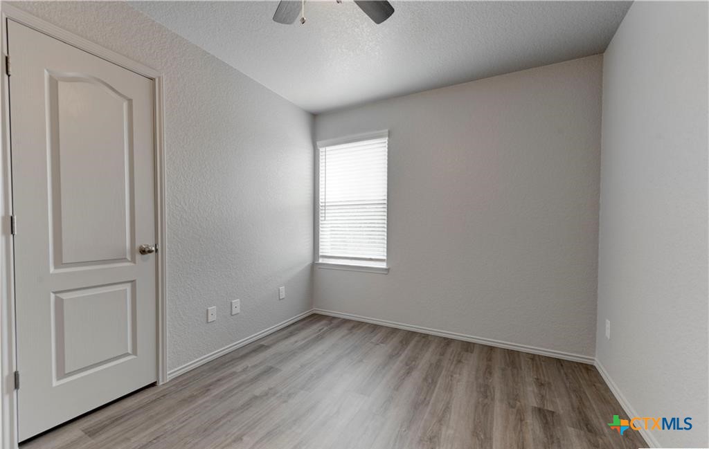 601 Lost Trail, Unit B Copperas Cove, TX 76522 - Photo 20 of 27 an empty room with wooden floor and windows