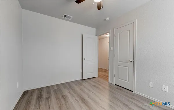 a view of an empty room with wooden floor