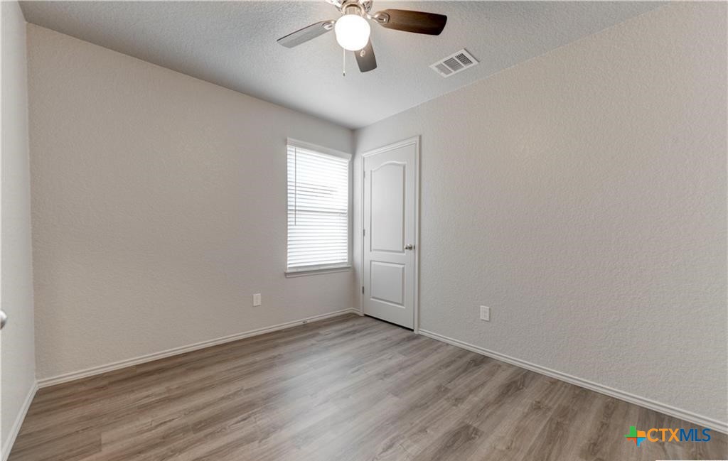 601 Lost Trail, Unit B Copperas Cove, TX 76522 - Photo 22 of 27 an empty room with a window and a chandelier fan