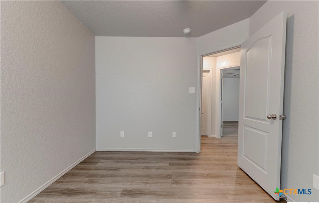 601 Lost Trail, Unit B Copperas Cove, TX 76522 - Photo 24 of 27 a view of an empty room with wooden floor and a hallway
