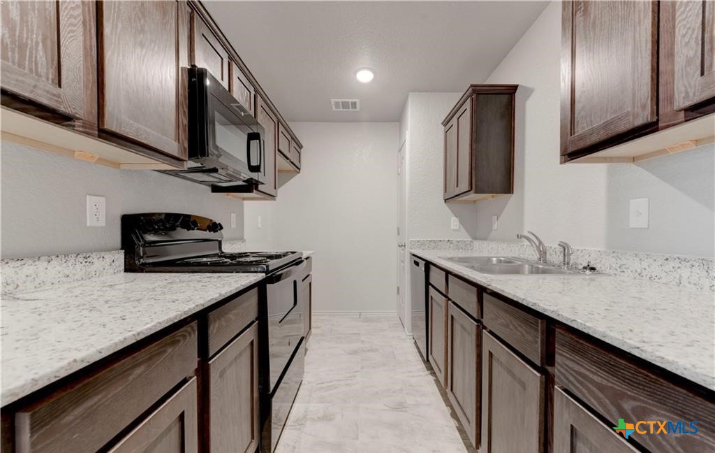 601 Lost Trail, Unit B Copperas Cove, TX 76522 - Photo 10 of 27 a kitchen with stainless steel appliances granite countertop a sink stove and refrigerator