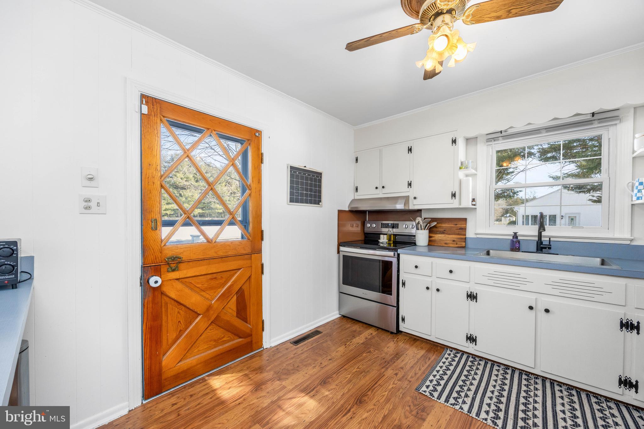 3750 Sunnyside Road East New Market, MD 21631 - Photo 9 of 45 a kitchen with stainless steel appliances a stove a sink cabinets and a window
