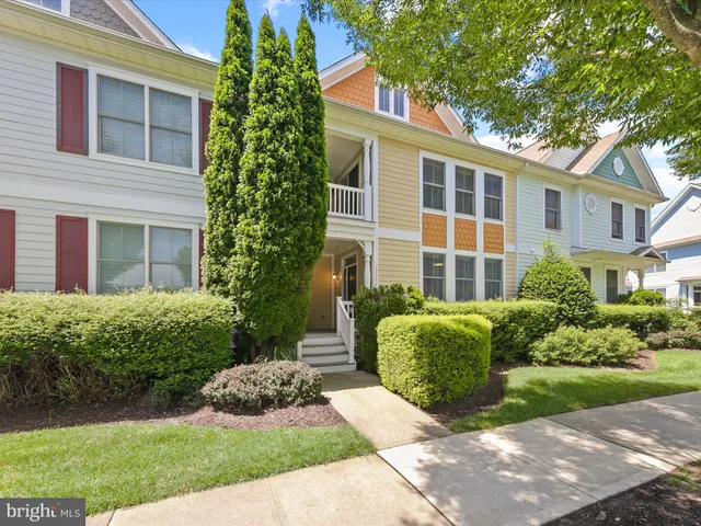 a view of a dining room and livingroom with furniture wooden floor a chandelier