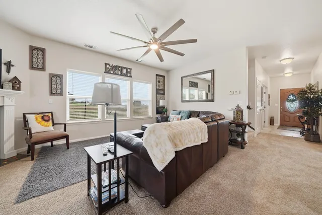 a spacious bedroom with a bed a couch and a chandelier
