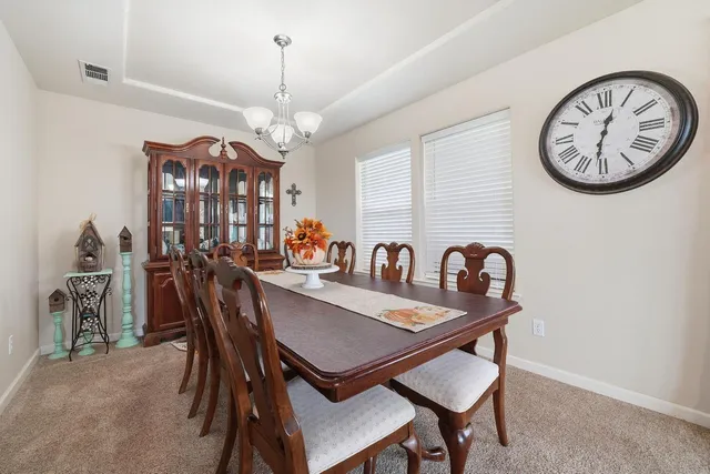 a view of a dining room with furniture and a chandelier