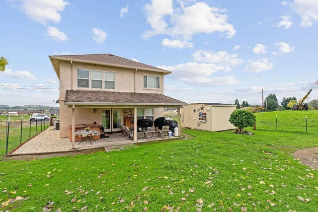 a view of a house with a yard and sitting area