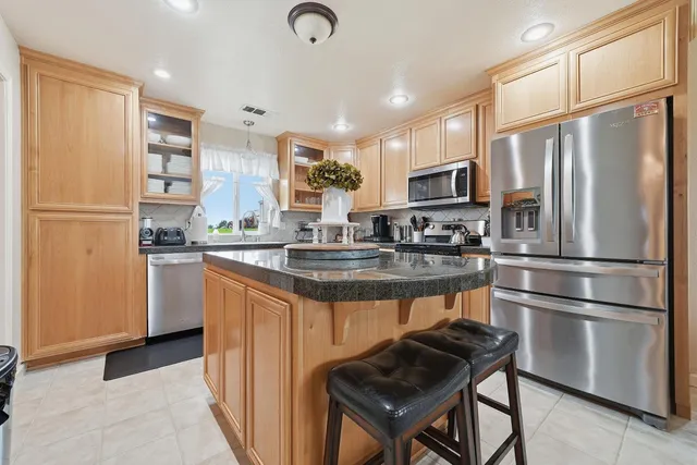 a kitchen with stainless steel appliances granite countertop a refrigerator stove microwave and sink