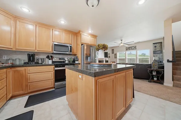 a kitchen with stainless steel appliances granite countertop a stove a sink a refrigerator and cabinets