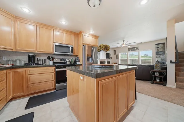 a kitchen with stainless steel appliances granite countertop a stove a sink a refrigerator and cabinets