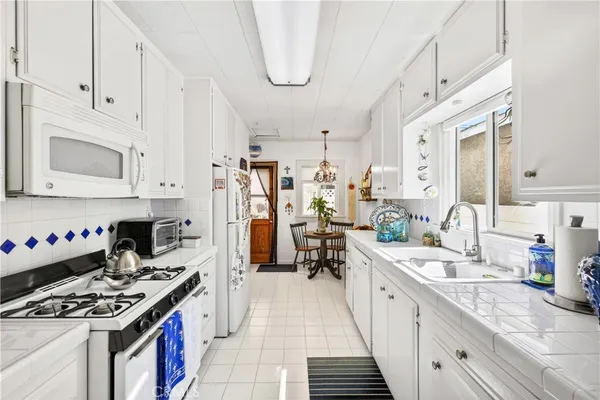 a kitchen with stainless steel appliances a stove a sink dishwasher and cabinets with wooden floor