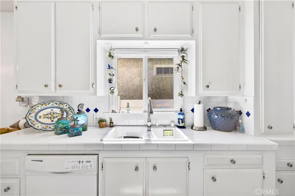 a kitchen with white cabinets and a sink